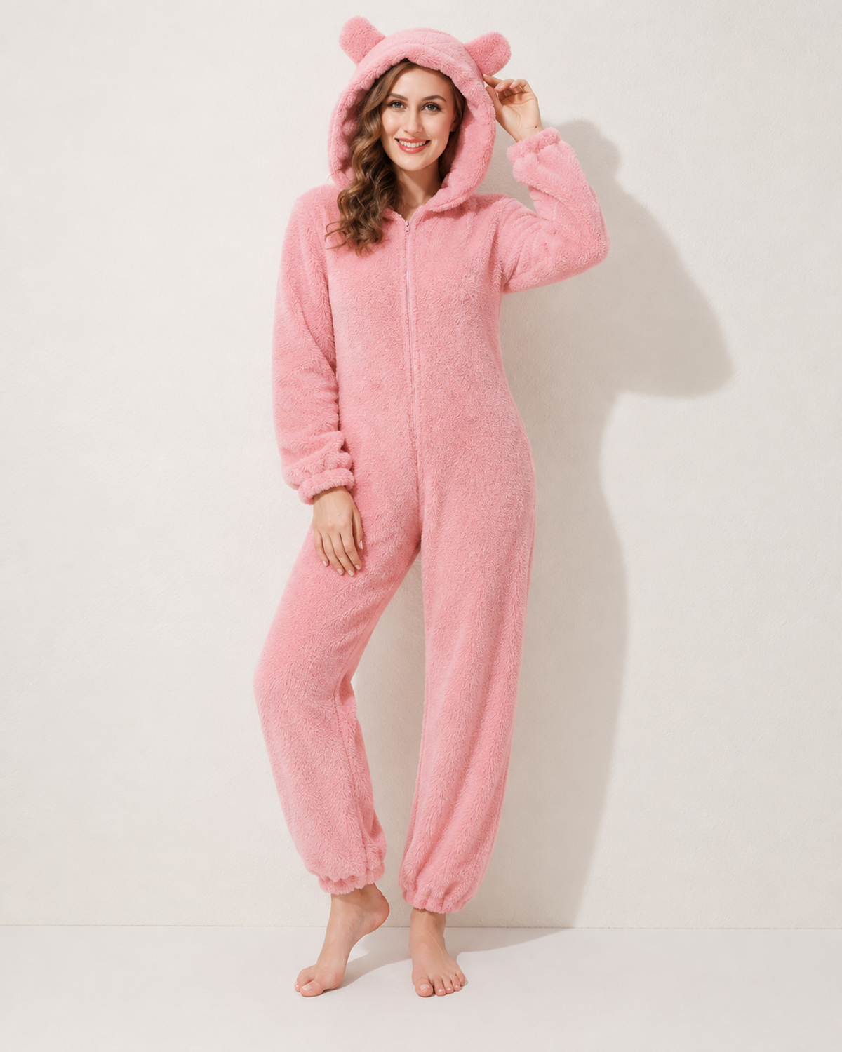 Women's pink bear-ear fleece onesie, front three-quarter studio view