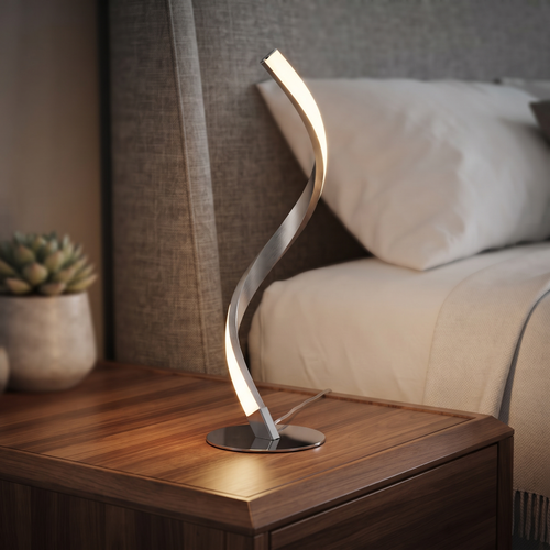 Chrome spiral LED table lamp glowing warm on a bedside table