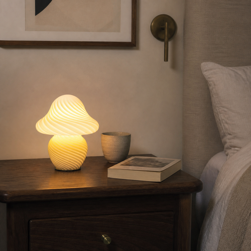 Yellow swirled mushroom table lamp on a walnut bedside table