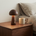 Walnut Willow wooden mushroom lamp on a bedside table beside a mug