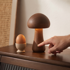 Hand using the touch control on the Walnut Willow mushroom lamp