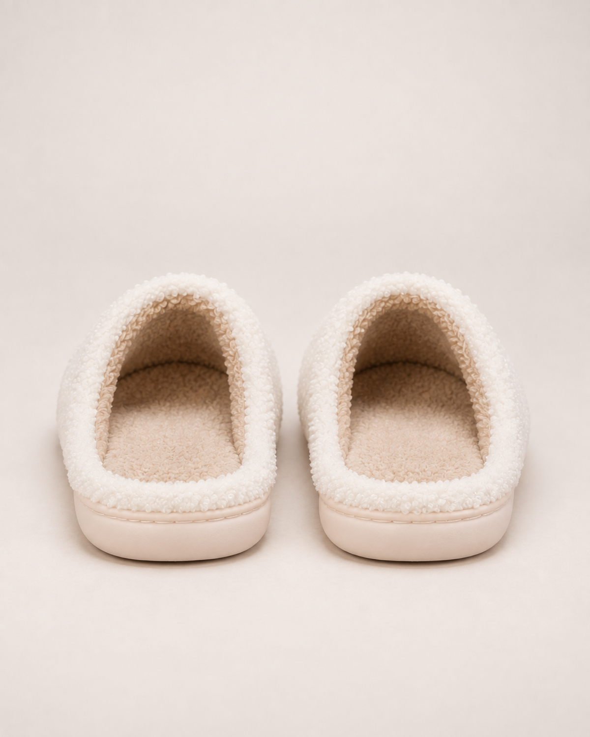 White embroidered capybara slippers showing their open backs and heel construction