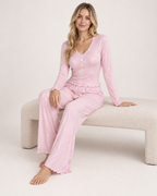 Women's pink V-neck button-front pyjama set, seated studio view