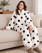 Women's white polka-dot fleece pyjama set, seated lounge view