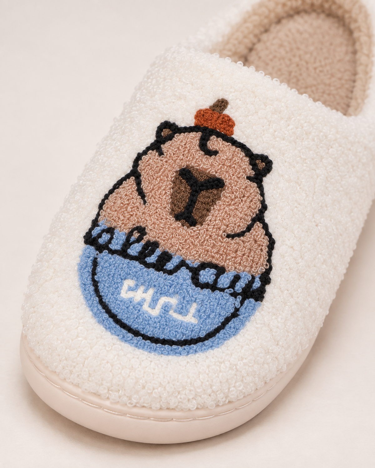 Close view of the capybara embroidery, looped fleece and stitched sole