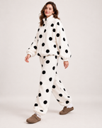 Women's white polka-dot fleece pyjama set, walking studio view