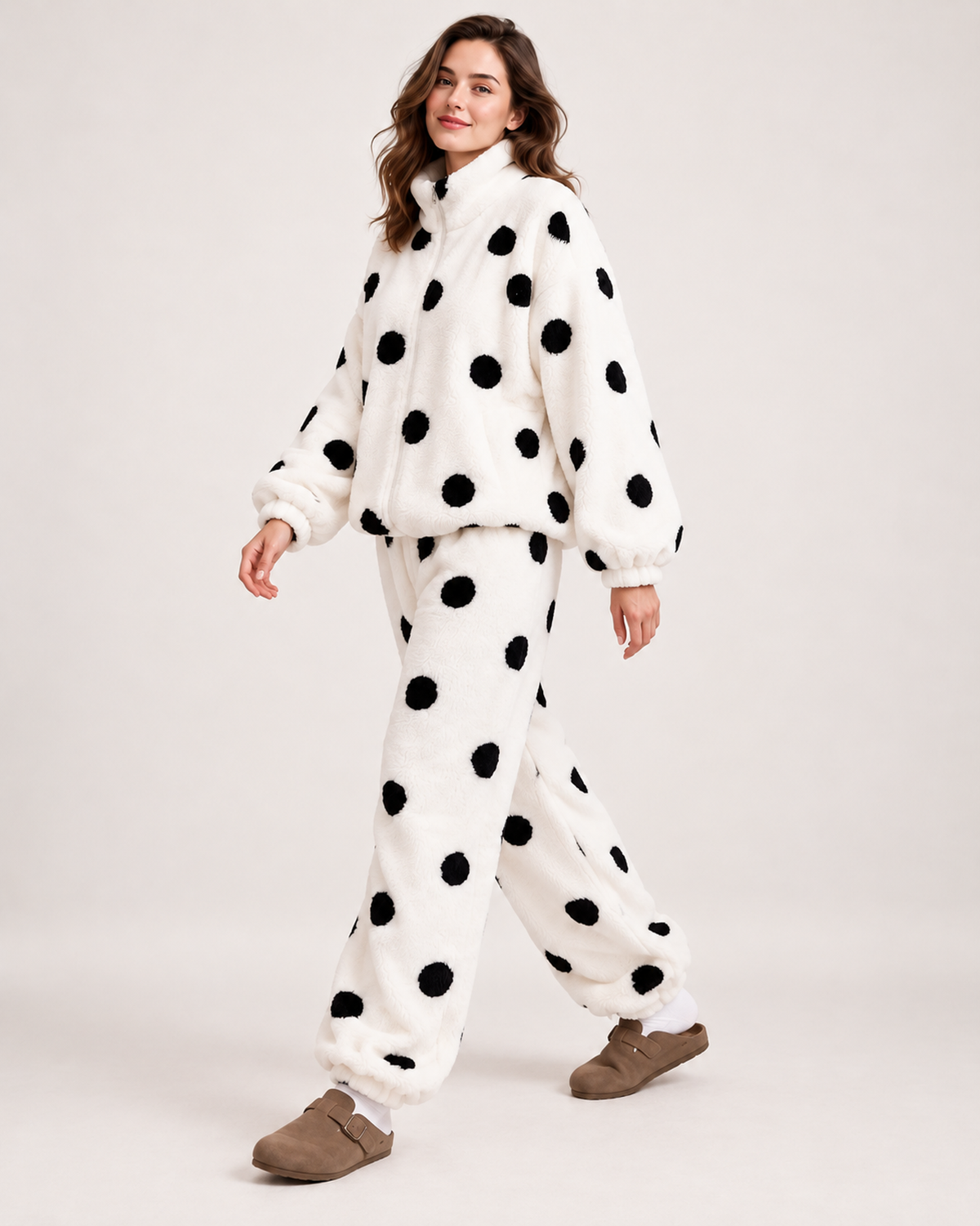 Women's white polka-dot fleece pyjama set, walking studio view