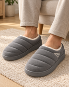 Men's grey quilted plush slippers, relaxed indoor lifestyle view