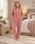 Women's pink cat-ear fleece onesie, bright bedroom lifestyle view