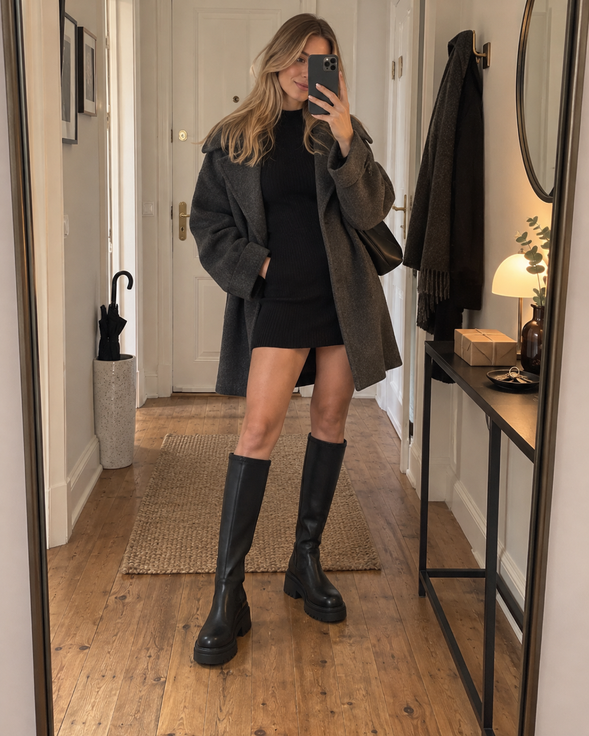 Woman taking an entrance-hall mirror selfie in black knee-high platform boots