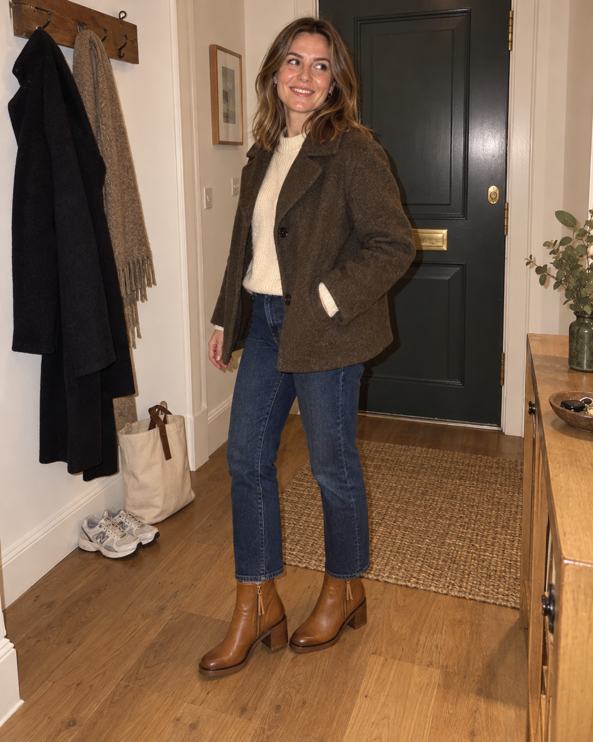 Woman in an evening entryway wearing brown chunky block heel ankle boots