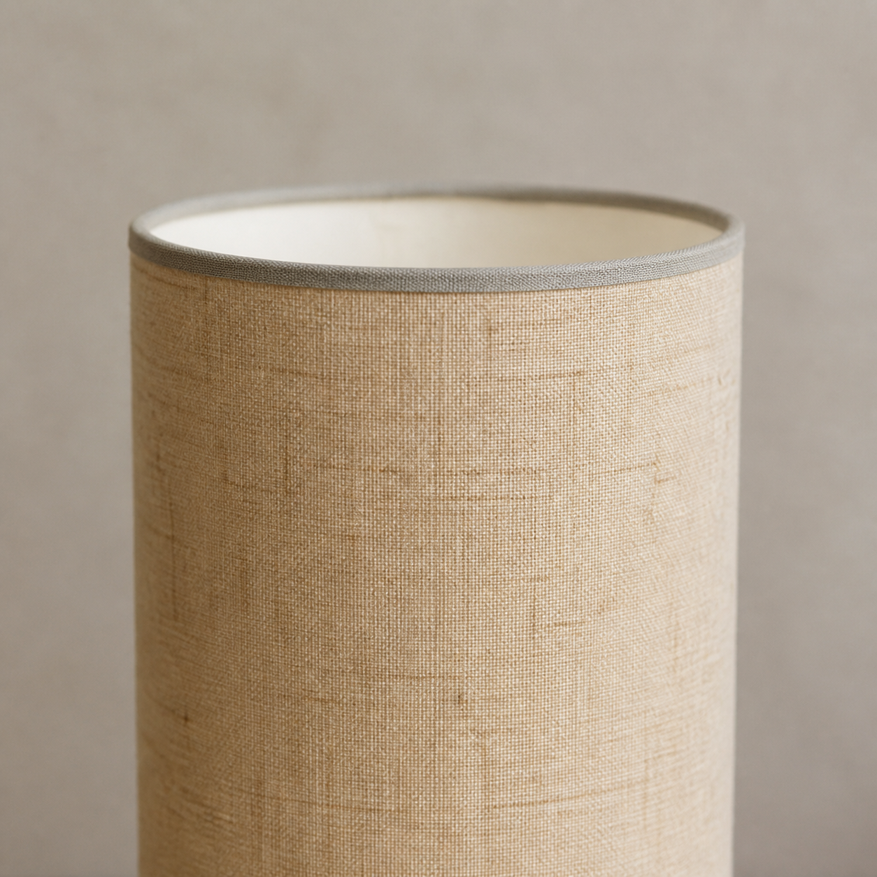 Close-up of the beige woven shade and narrow bound rim