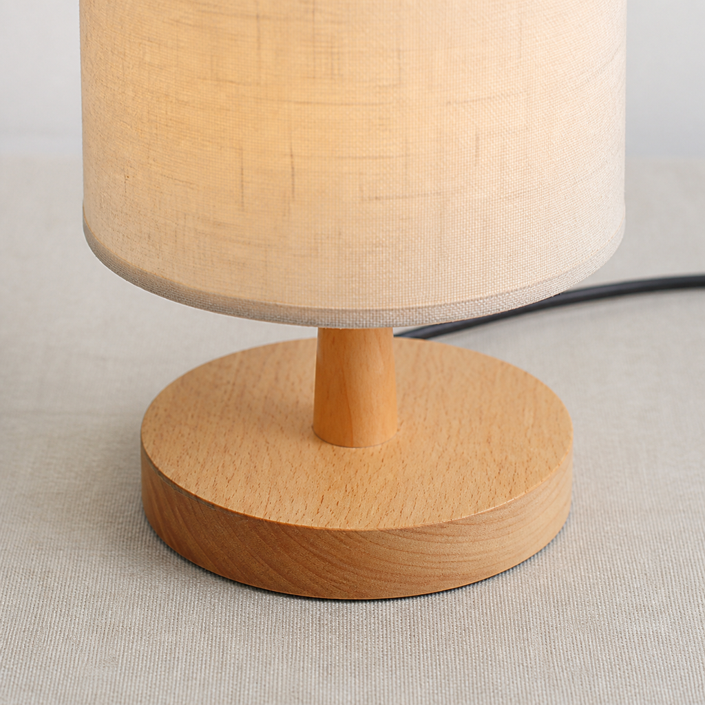 Detail of the round wooden base and short stem beneath the beige shade