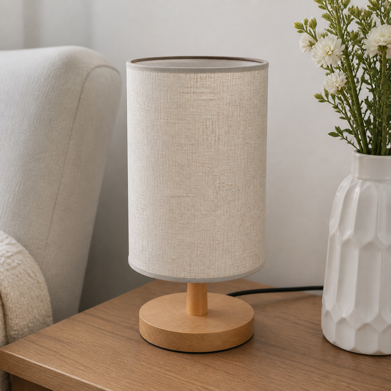 Beige wooden table lamp beside a neutral upholstered chair