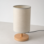 Angled view of the beige table lamp with its black power cord