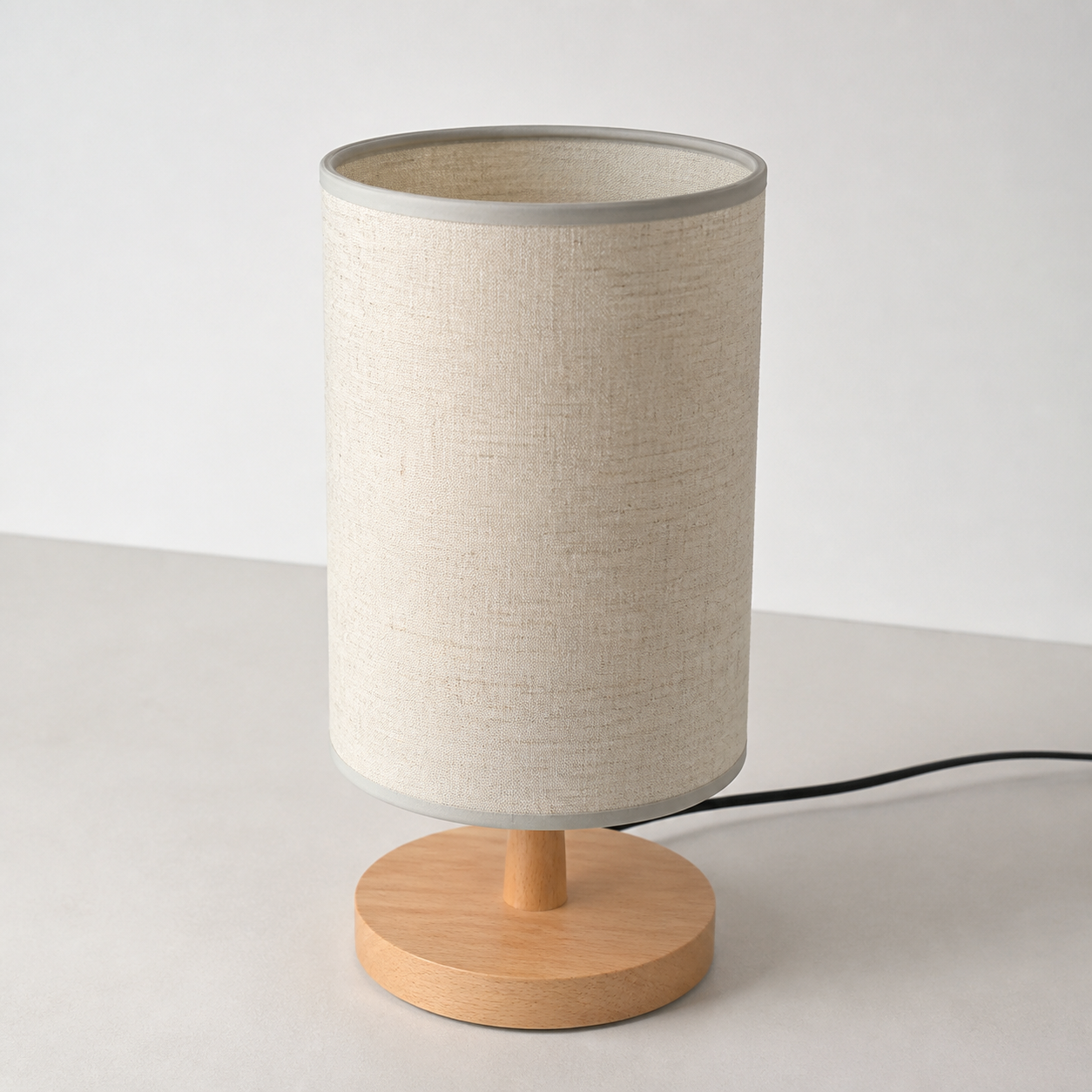 Angled view of the beige table lamp with its black power cord